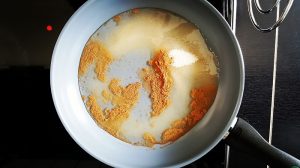 Gebrannte Walnüsse Zucker und Wasser in der Pfanne erhitzen