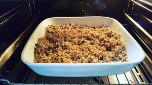 Knuspermüsli-ohne-Palmöl-und-ohne-Plastik-selber-machen: Wasser-Öl-Sirup-Mischung über die Haferflocken gebenKnuspermüsli-ohne-Palmöl-und-ohne-Plastik-selber-machen: Mischung im Backofen backen